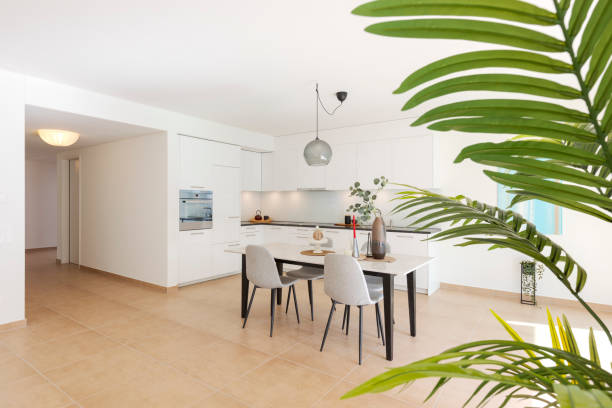 istock Large modern white kitchen with a marble table and four chairs in front. This is the interior of a modern flat. 2147588277