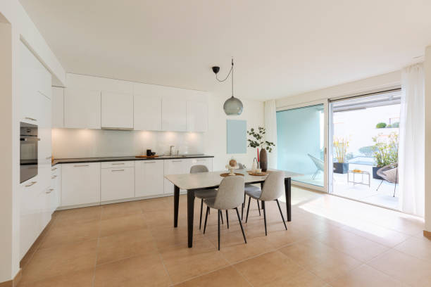 istock Large kitchen with dining table inside. Modern space and a window opening onto a terrace. 2147589011
