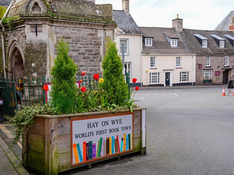 5th April 2024: A flower planter sign welcomes visitors to Hay-on-Wye,  promoting the town's book fame. The historic market town in Powys, South Wales is famous for its many book shops, selling second hand and new books, as well as hosting a popular annual literary festival.
