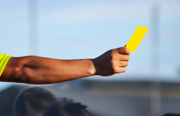 A hand showing a yellow card