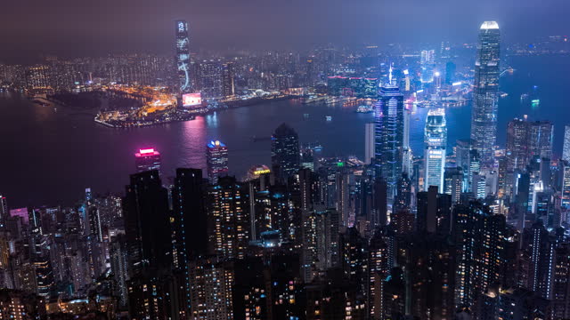 Time lapse peak of Hong kong view with cityscape in night with fog and strong wind