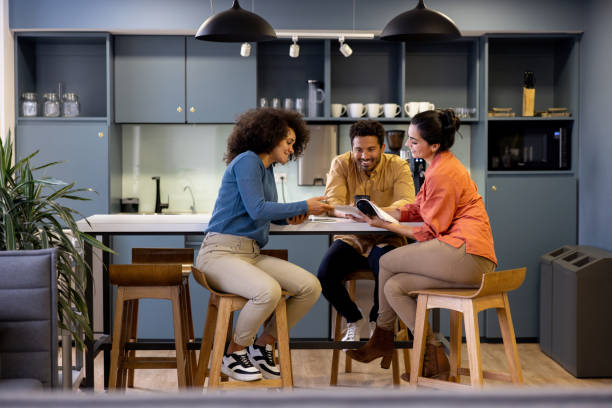 Business people sharing ideas in the kitchen at a coworking office
