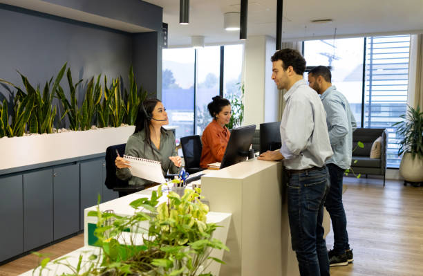 istock Friendly receptionists talking to clients at the office 2147591232