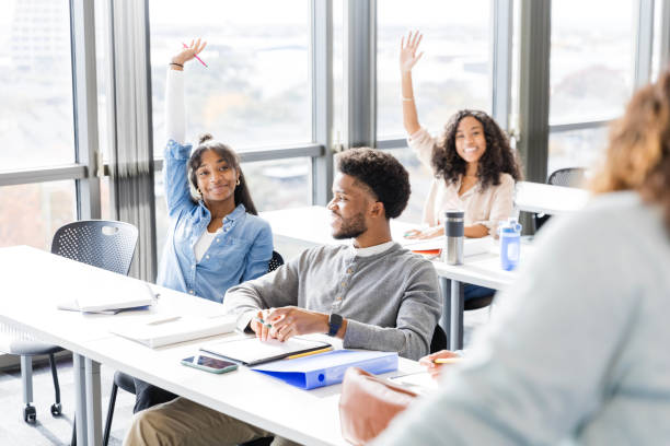 istock Diverse group of students eagerly raise their hands to volunteer 2147592194