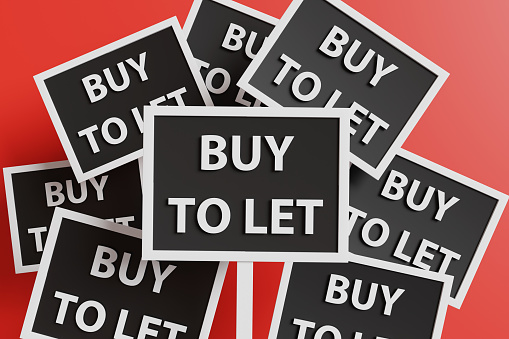 Black pickets with a white border and the words BUY TO LET on red background. Illustration of the concept of leasing business and rental market of residential houses