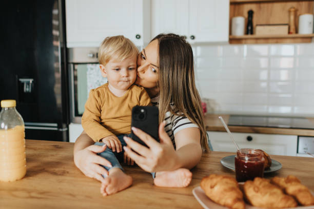 istock Mother and son taking selfie during breakfast at home 2147595249
