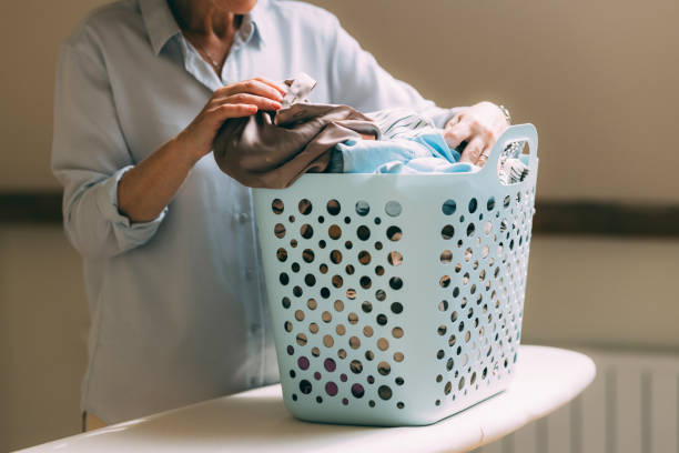 istock Mature Woman Folding Clothes in Her Laundry Room 2147595355