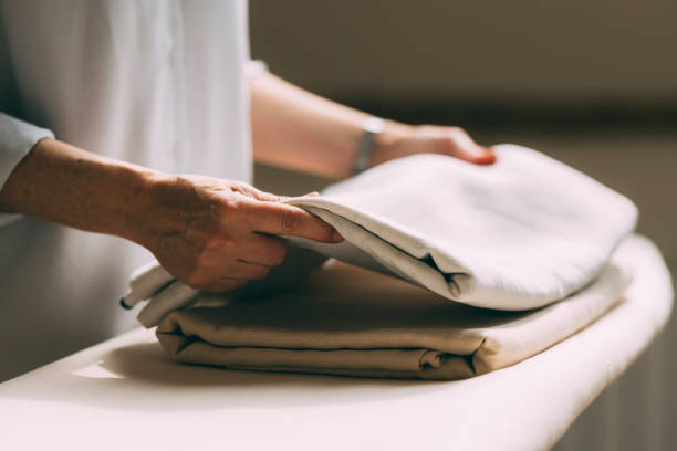 istock Mature Woman Folding Laundry at Home with Care 2147595360