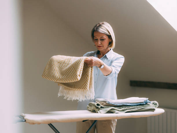istock Mature Woman Ironing and Folding Laundry at Home 2147595371