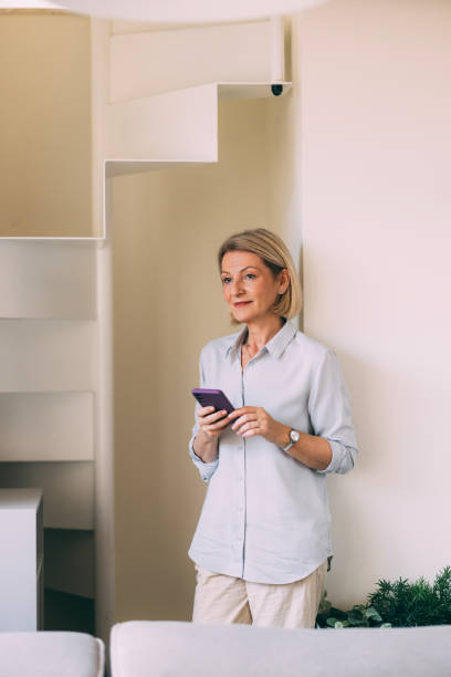 istock Mature Woman Using Smartphone at Modern Home 2147595455