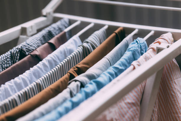 Close-up of an open wardrobe with various neatly folded and arranged clothes, showcasing organization and tidiness in clothing storage.