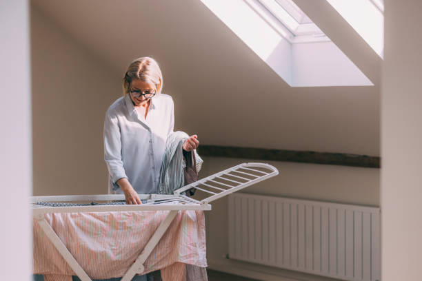 Woman Hanging Clothes on Drying Rack Indoors
