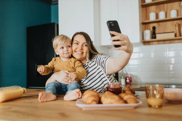 istock Mother and son taking selfie during breakfast at home 2147595514