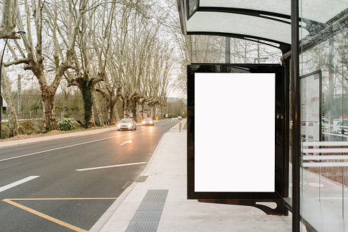 Bus stop with blank billboard in a city avenue