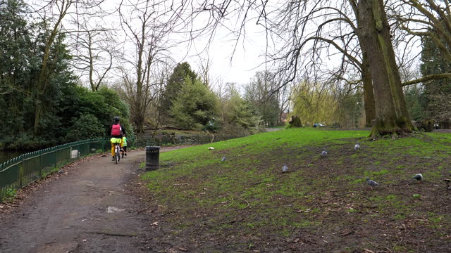 Woman and her child riding bicycles in Alexandra Park.