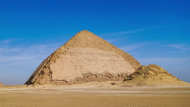 The Bent Pyramid is an ancient Egyptian pyramid located at the royal necropolis of Dahshur, approximately 40 kilometres south of Cairo, built under the Old Kingdom Pharaoh Sneferu. Egypt