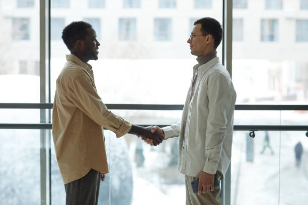 istock Black And Caucasian Man Shaking Hands 2147598831