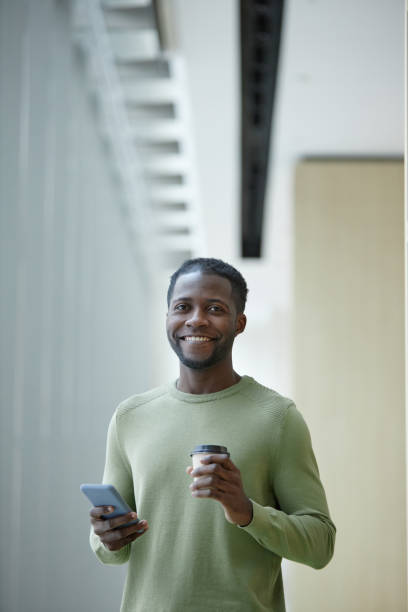 istock Black Man Holding Coffee Cup in Office Building 2147598841