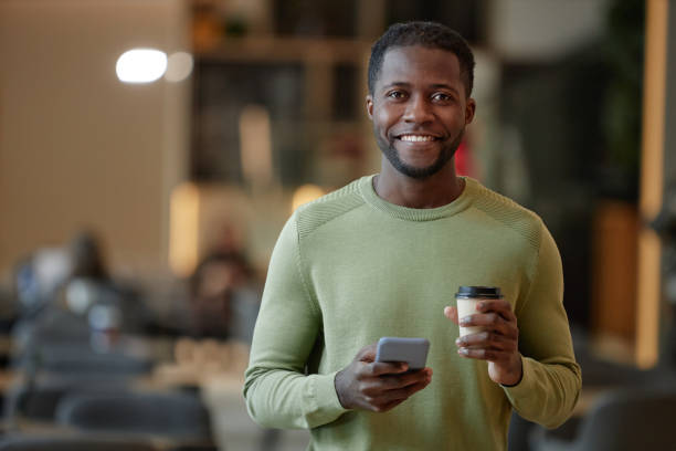 istock Smiling Black Man Holding Smartphone 2147598849