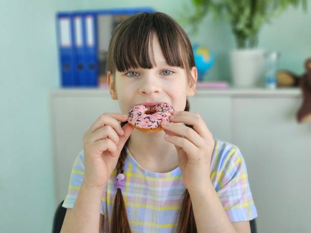 istock Cute girl eats sweet donuts concept 2147600269