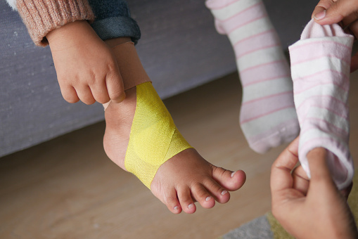 Elastic therapeutic yellow tape applied to child leg. .