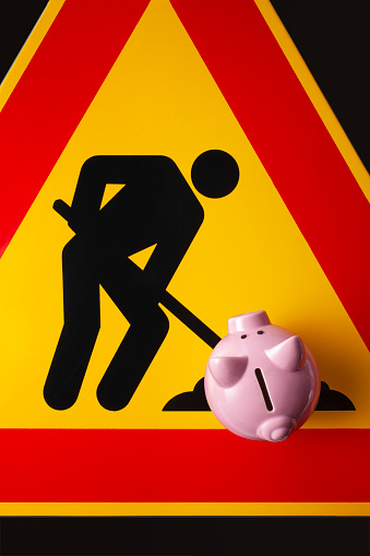 I save with work. Piggy bank on a roadworks sign.