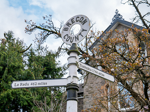 Sign with mileage distances to Timbuktu in Mali, Africa & Le Redu in Belgium, that stands in the historic Welsh town of Hay-on-Wye. It is a reference to the Powys town being twinned with the two locations. Hay is famous for its secondhand bookshops and annual literary festival.
