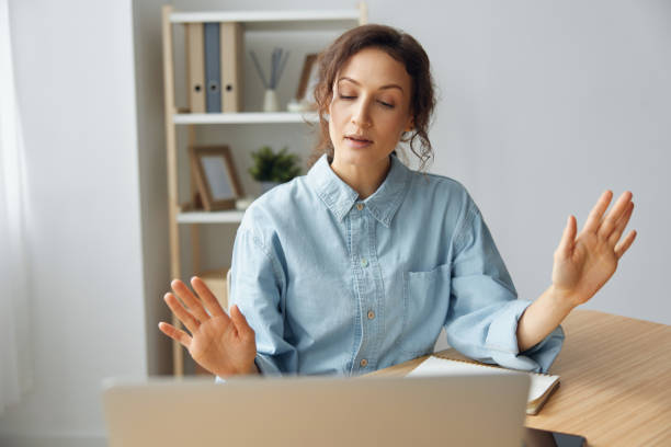 istock Raging evil curly awesome lady shocked by gadget laptop breakdown operational problems raising hands up sitting at home office. Irritated by bad gadget work businesswoman trying to calm down 2147607311