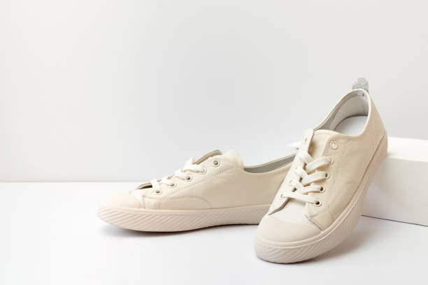 Pair of stylish sneakers on white background with geometric podium