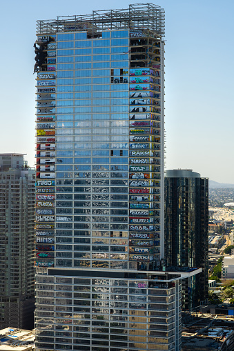 An abandoned skyscraper covered in colorful graffiti in Downtown Los Angeles, California on a sunny day.