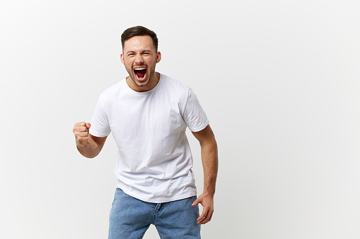 Abusive relationships concept. Aggressive angry crazy handsome man in basic t-shirt scream swings fist posing isolated on over white studio background. Copy space Banner Mockup. People emotions