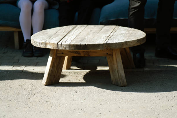 A rough wooden coffee table with a round lid made of thick boards