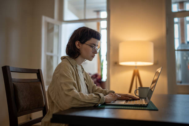 Focused girl freelancer working on laptop sits in workplace at home, learn english language online