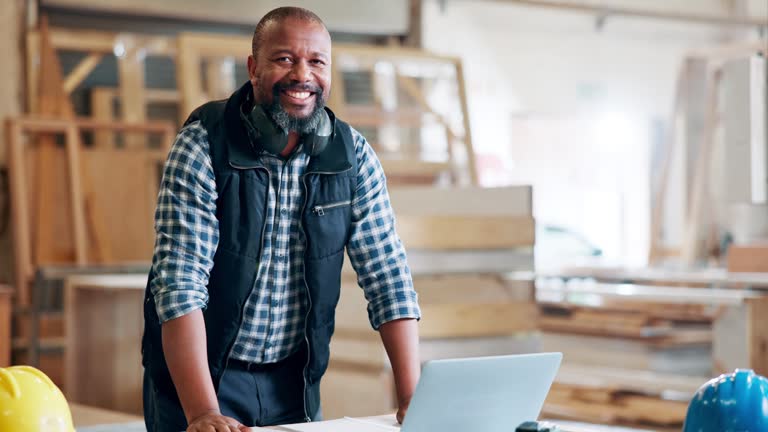 Black man, architect and smile at workplace with laptop for building ideas, plan and design online. Mature person, portrait and happy as engineer with startup business and construction project