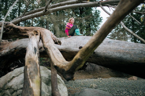 istock Girl Climbing Fallen Trees At Beach 2147613163