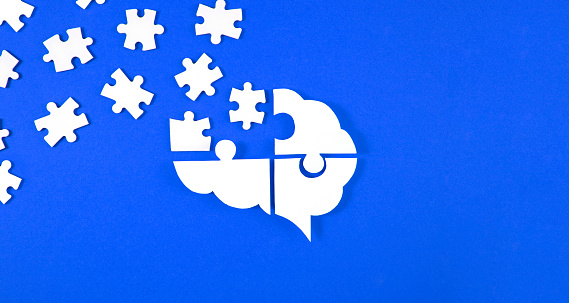 Brain shaped puzzle pieces on blue background