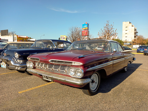 Buenos Aires, Argentina - May 28, 2023: old red 1959 Chevrolet Impala hardtop sedan at a classic car show in a parking lot. Copy space