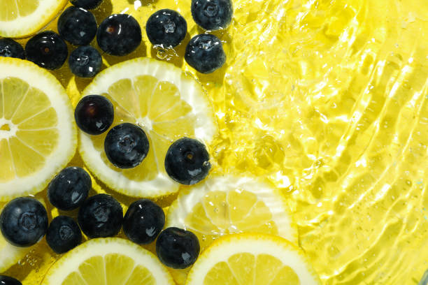 istock Lemon slices and blueberry in water on yellow background 2147616706