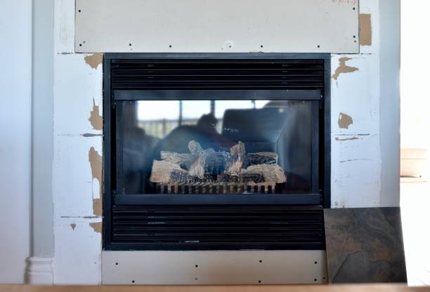 Home renovation projects, simple weekend construction to update and modernize the living room Home renovation projects replacing tile surround on gas fireplace in family room to revitalize the room drywall fireplace stock pictures, royalty-free photos & images