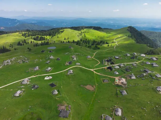 Photo of Aerial View of Mountain Cottages on Green Hill of Velika Planina Big Pasture Plateau, Alpine Meadow Landscape, Slovenia