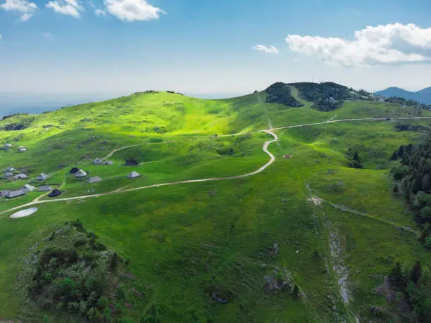 Photo of Aerial View of Mountain Cottages on Green Hill of Velika Planina Big Pasture Plateau, Alpine Meadow Landscape, Slovenia