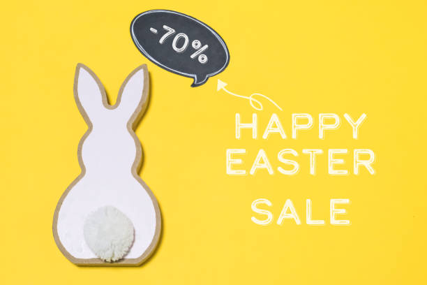 a rabbit is on a yellow background with a sign that says happy easter sale - animal egg eggs basket yellow fotografías e imágenes de stock