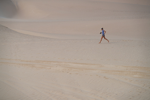 Side view of a running and  photographing morning at White dunes, called Sugar dunes at Al Khaluf, Oman. It is south part of Wahiba desert, near Arabian sea.