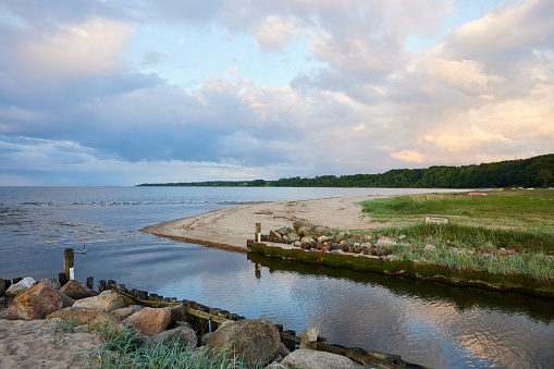 Picturesque view of grassy idyllic beach and calm seascape under cloudy sky during daytime at Denmark