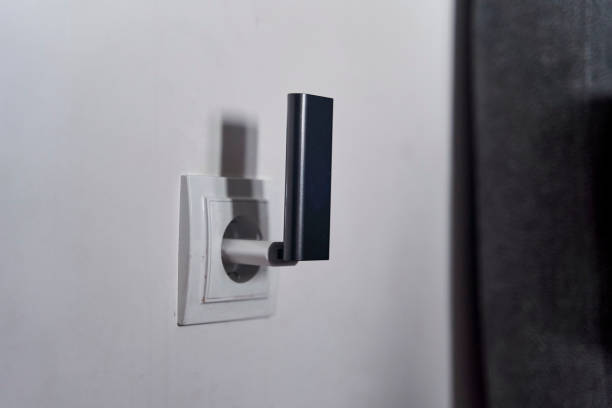 istock A black wi-fi router is connected to a white outlet on a white wall 2147623486