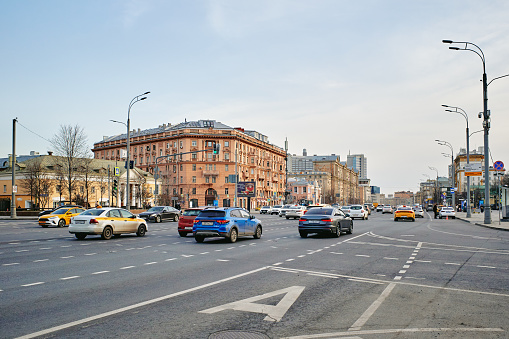 Moscow, Russia - March 31, 2024: One of the main streets of Moscow Tverskaya street on spring evening with old houses and cars on the road, Russia, clear blue sky.
