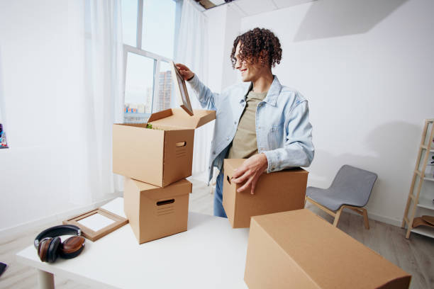 istock A young man unpacking things from boxes in the room interior 2147627279
