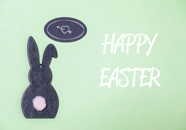 A rabbit is sitting on a green background with a heart and an arrow. The rabbit is surrounded by a white border