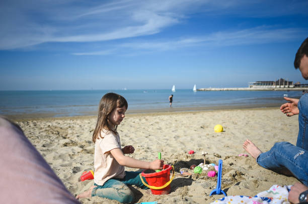 istock Daughter playing with sand in a spring day. 2147629325