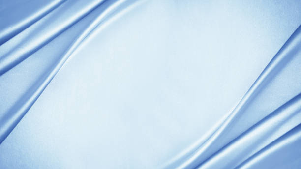 Light blue silver white silk satin fabric background. Drapery. Pastel soft pale. Fresh freshness purity clean washing laundry. Table top view.